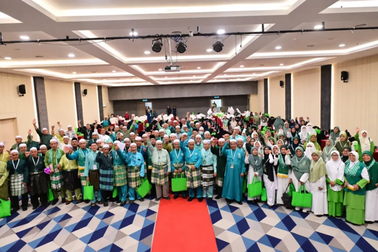 Peserta lelaki dan wanita bergambar bersama dalam perhimpunan program Islam di dalam dewan