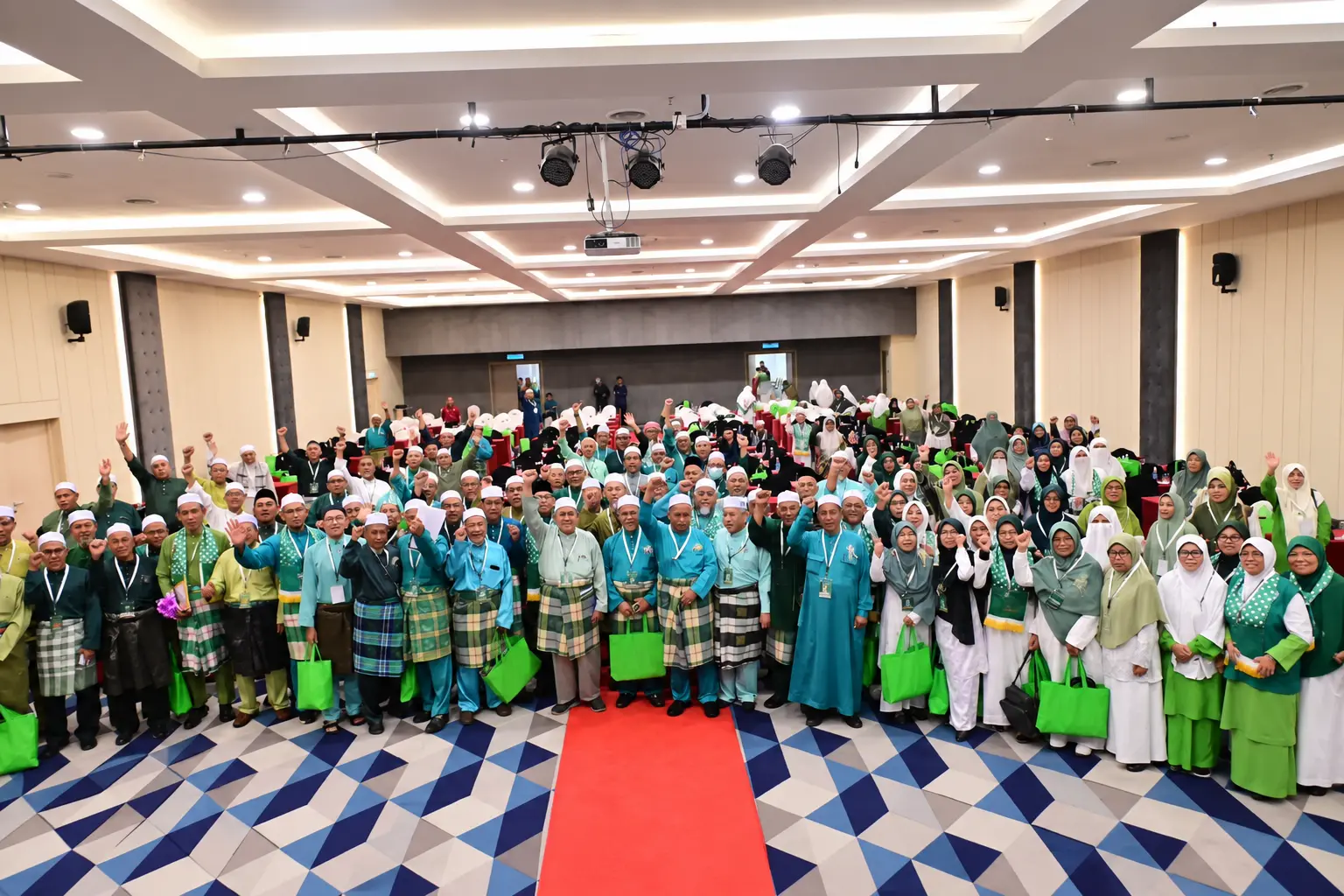 Peserta lelaki dan wanita bergambar bersama dalam perhimpunan program Islam di dalam dewan